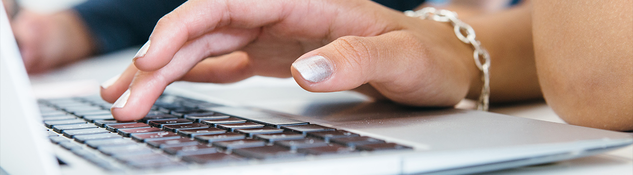 A teammate at Needs is using their laptop to communicate to customers.